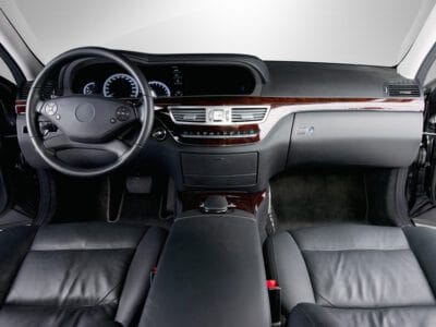 A car interior with the dashboard and steering wheel.