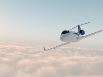 A plane flying through the air with clouds in background.