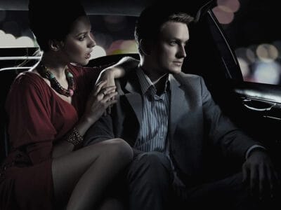 A man and woman sitting in the back of a car.